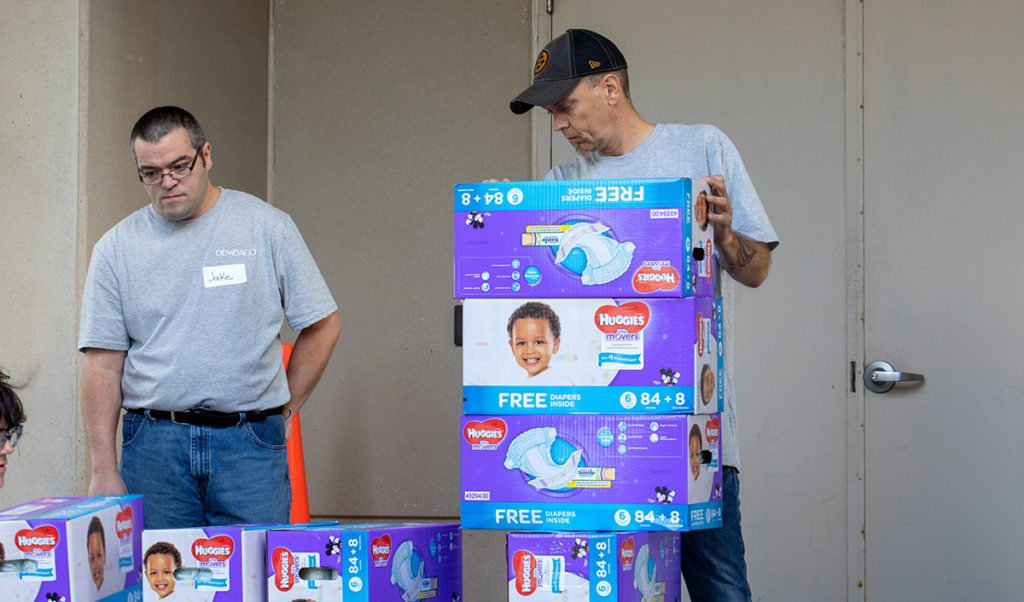 DEMDACO colleagues organizing cases of diapers for HappyBottoms.